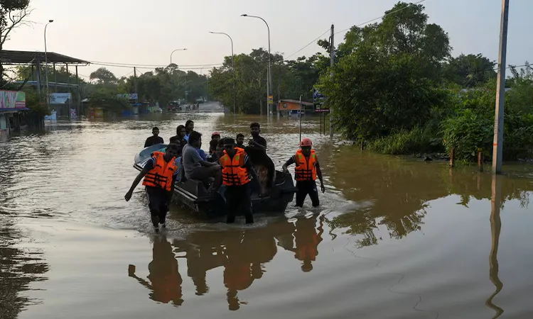 People ride on a boat belonging to Sri Lanka's army at a flooded area following Cyclone Ditwah in Kelaniya, Sri Lanka: Photo RUETERS