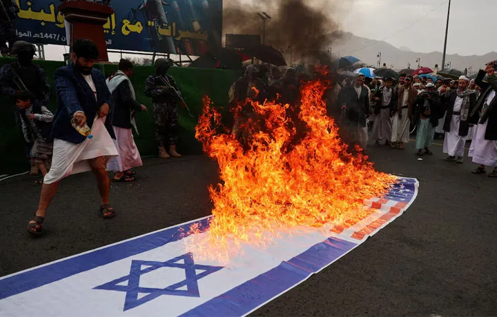 Houthi activists burn U.S. and Israeli flags during a demonstration in solidarity with Iran and Lebanon, amid the U.S.-Israeli conflict with Iran, in Sanaa, Yemen.