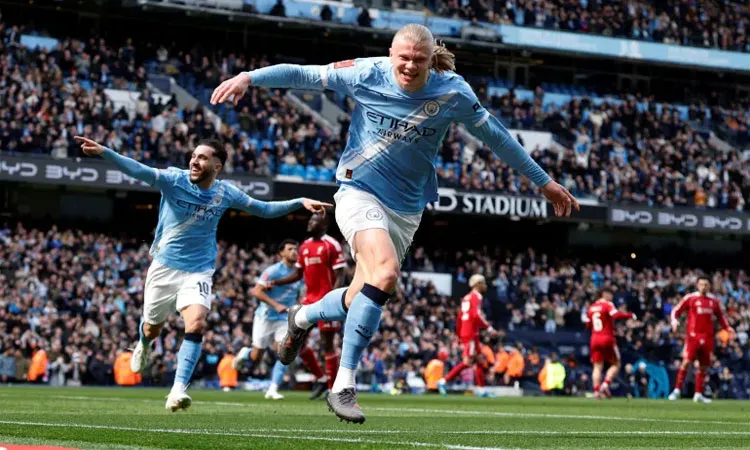 Manchester City's Erling Haaland celebrates scoring their first goal with Rayan Cherki