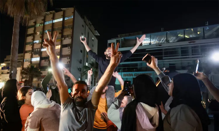 A crowd celebrates as displaced people return to their homes after a 10-day ceasefire between Lebanon and Israel went into effect, in Sidon, Lebanon.