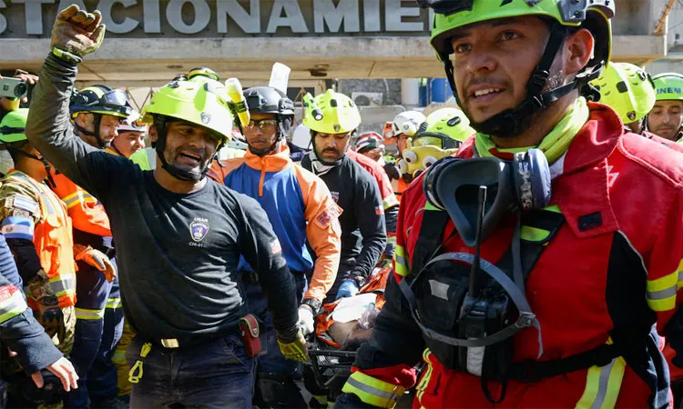 Rescue workers transport survivor Hernan Alberto Gil, who was trapped for over a week at a collapsed mall following June 24 earthquakes, in La Guaira, Venezuela.