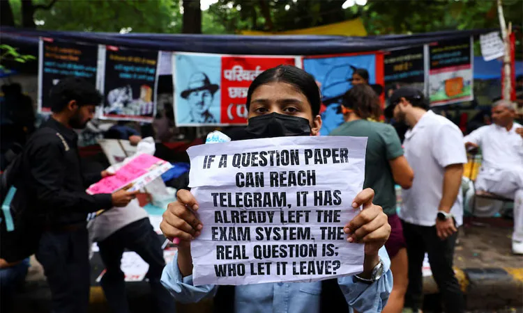 A supporter of India's Cockroach Janata Party (CJP) holds a sign during the ongoing protests, a few days after thousands of protesters marched towards parliament demanding the resignation of Education Minister Dharmendra Pradhan.
