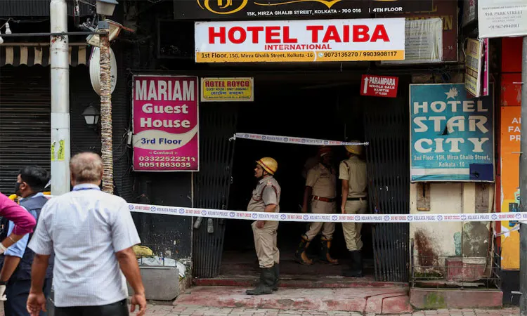 Firefighters stand at an entryway to a hotel where a fire broke out and killed several people in Kolkata: Photo collected