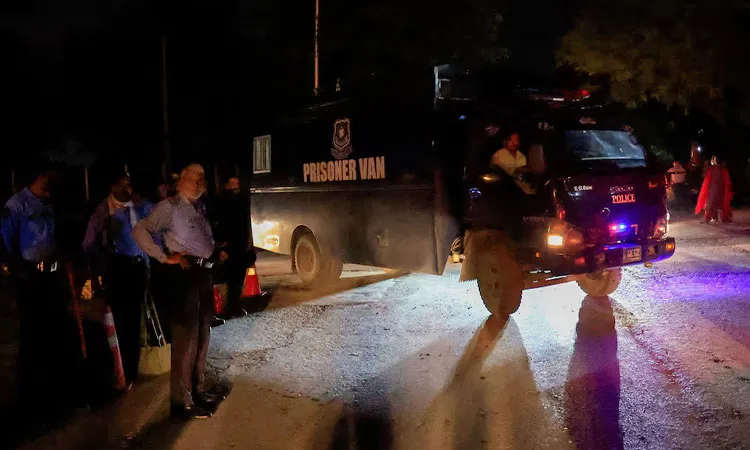 A prison van moves past police officers guarding the road leading to Shifa International Hospital.