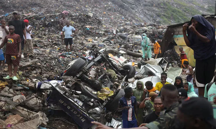 People gather at a landfill after a landslide with triggered by heavy overnight rains and killed several people in Dar es Salam.