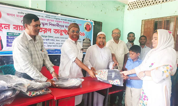 Gaibandha-3 MP Abul Kawsar Md. Nazrul Islam Lebu distributes school bags to students at Nurpur Government Primary School in Sadullapur.