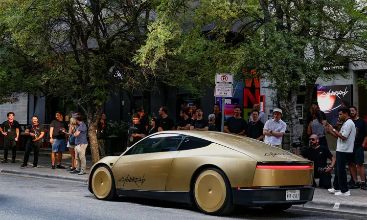 People look as a gold-colored Tesla Cybercab arrives for an event in downtown Austin, Texas, U.S.