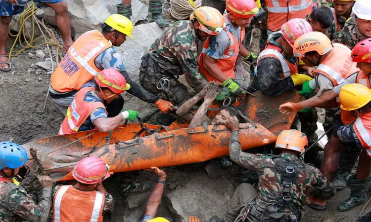 A survivor is carried by members of a search and rescue team after they rescued two people alive who had been trapped inside a tunnel at the Trishuli-3A Hydropower Tunnel.