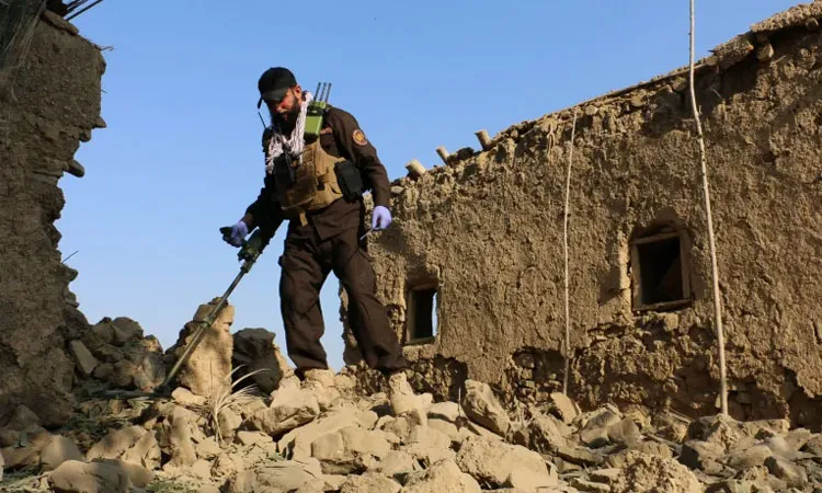 A member of Taliban security forces uses a metal detector amid the rubble of a house that was damaged in what the Taliban said was a Pakistani air strike in Gurbuz district of Khost province, Afghanistan