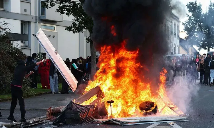 A fire blazes in the street as protesting students carry out a blockade in Brest.