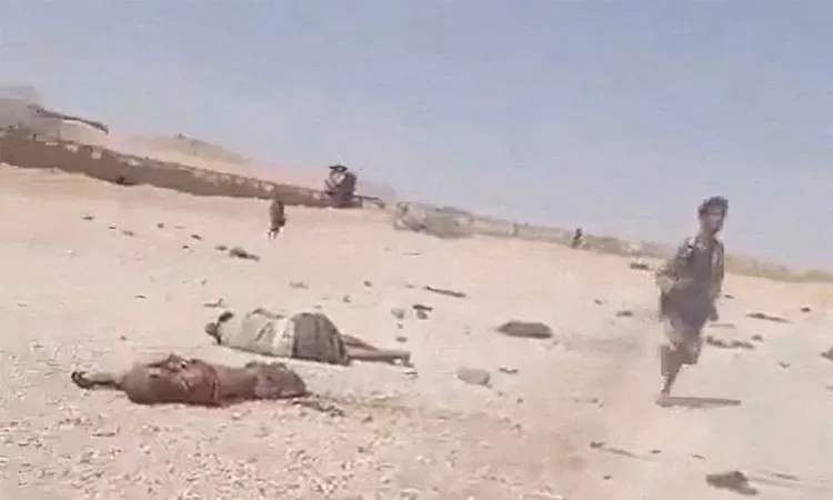 A screenshot from a video shows a person walking near bodies in the aftermath of a Houthi attack on Yemeni government military camp in Shabwa, Yemen.
