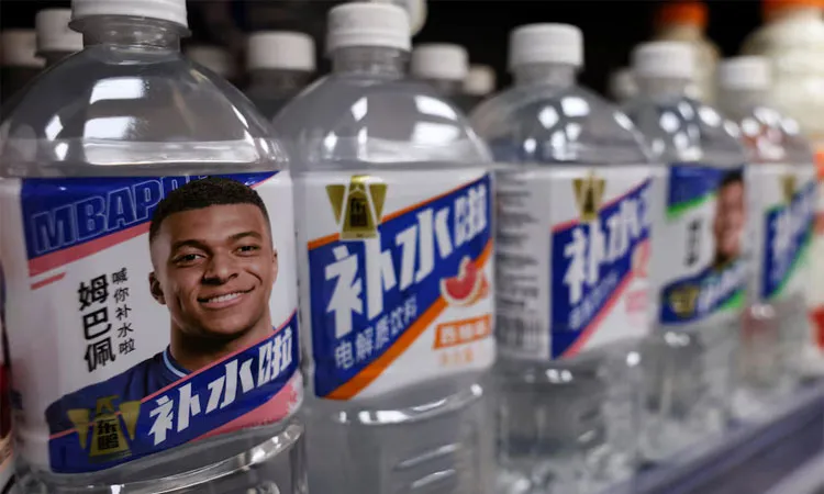 Bottled drinks by Eastroc Beverage with images of French soccer player Kylian Mbappe are displayed on a shelf at a store in Beijing, China.